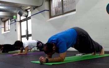Personas realizando actividades de elongación en gimnasio Usach