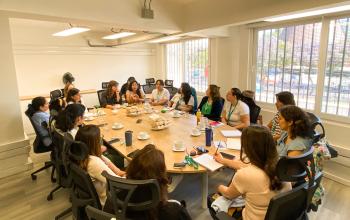 Mesa de reunión donde varias mujeres conversan acerca de los cuidados y sus desafíos