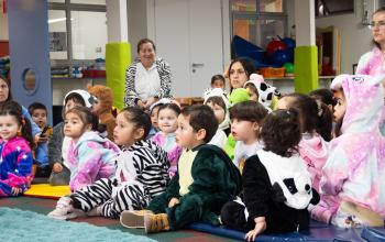 niños y niñas sentados en el piso del jardín infantil durante la celebración del Día de la Niñez