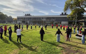 funcionarios y funcionarias de la FAHU en los pastos de ciencias realizando una pausa activa