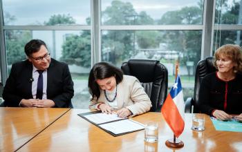Vicerrectora firmando enmesa de rectoria