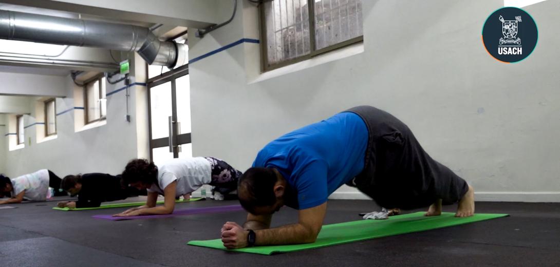 Personas realizando actividades de elongación en gimnasio Usach