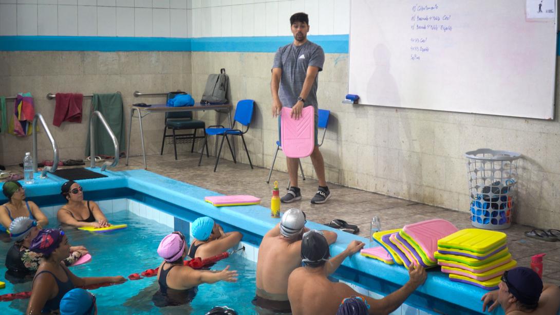 Profesor de natación entrega instrucciones a las personas funcionarias que participan del taller AFI