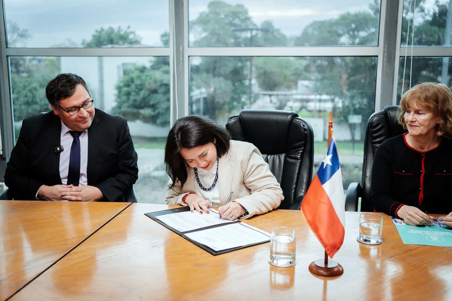 Vicerrectora firmando enmesa de rectoria